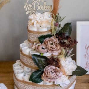 A baby shower cake made of diapers and flowers.