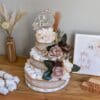 A cake that is made of diapers and flowers.