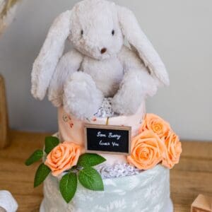 A white bunny rabbit sitting on top of a cake.