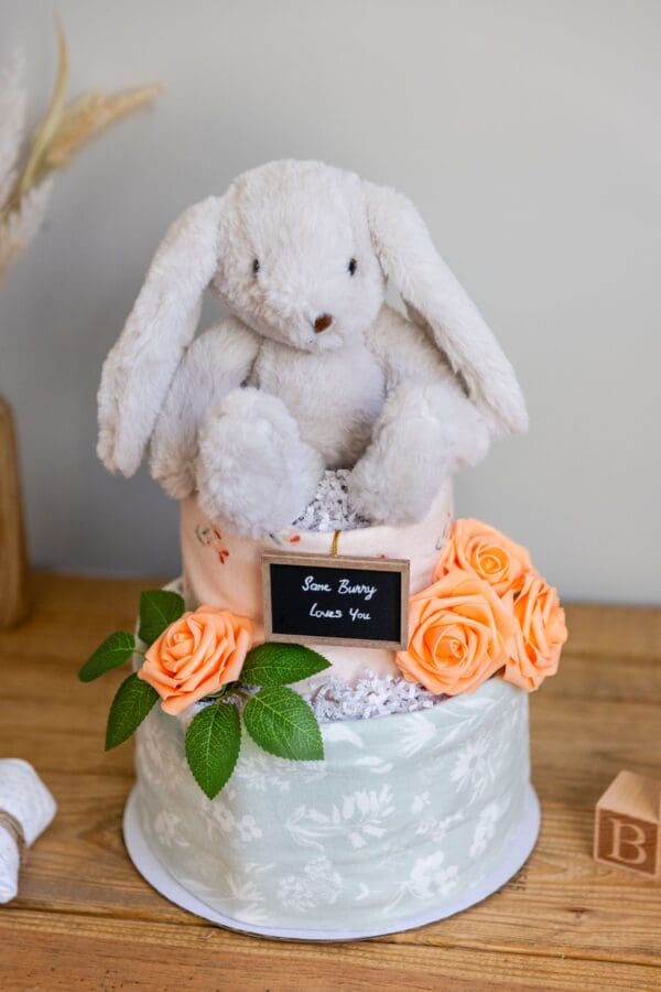 A white bunny rabbit sitting on top of a cake.
