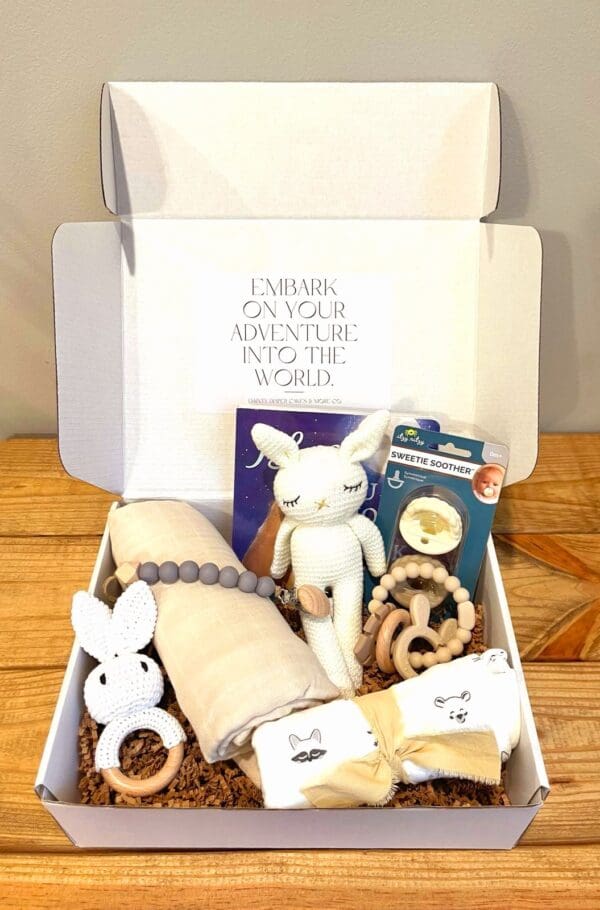 Baby gift box with a blanket, book, and toys.
